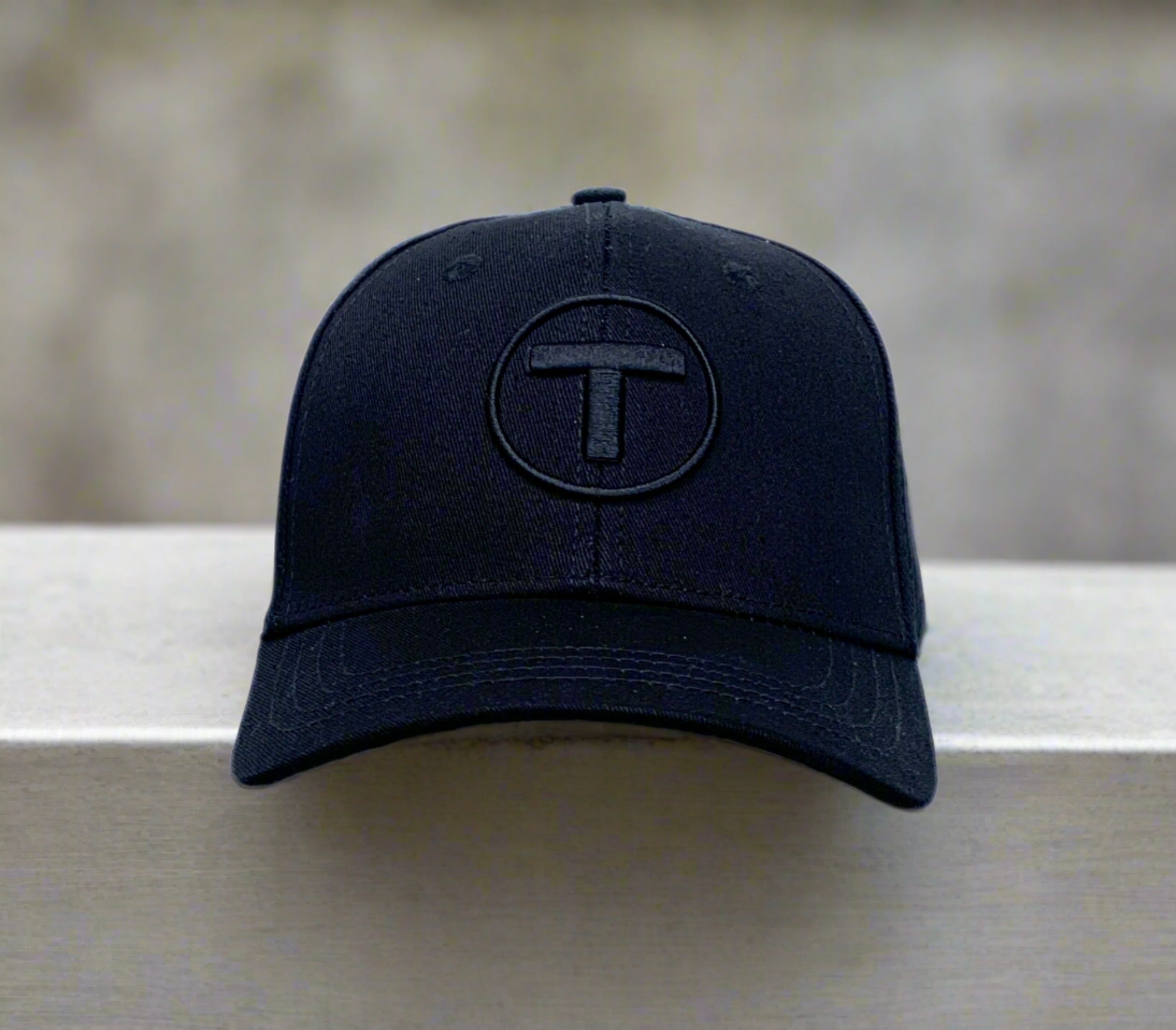 Front view of black youth cap with puff embroidered MBTA T Logo